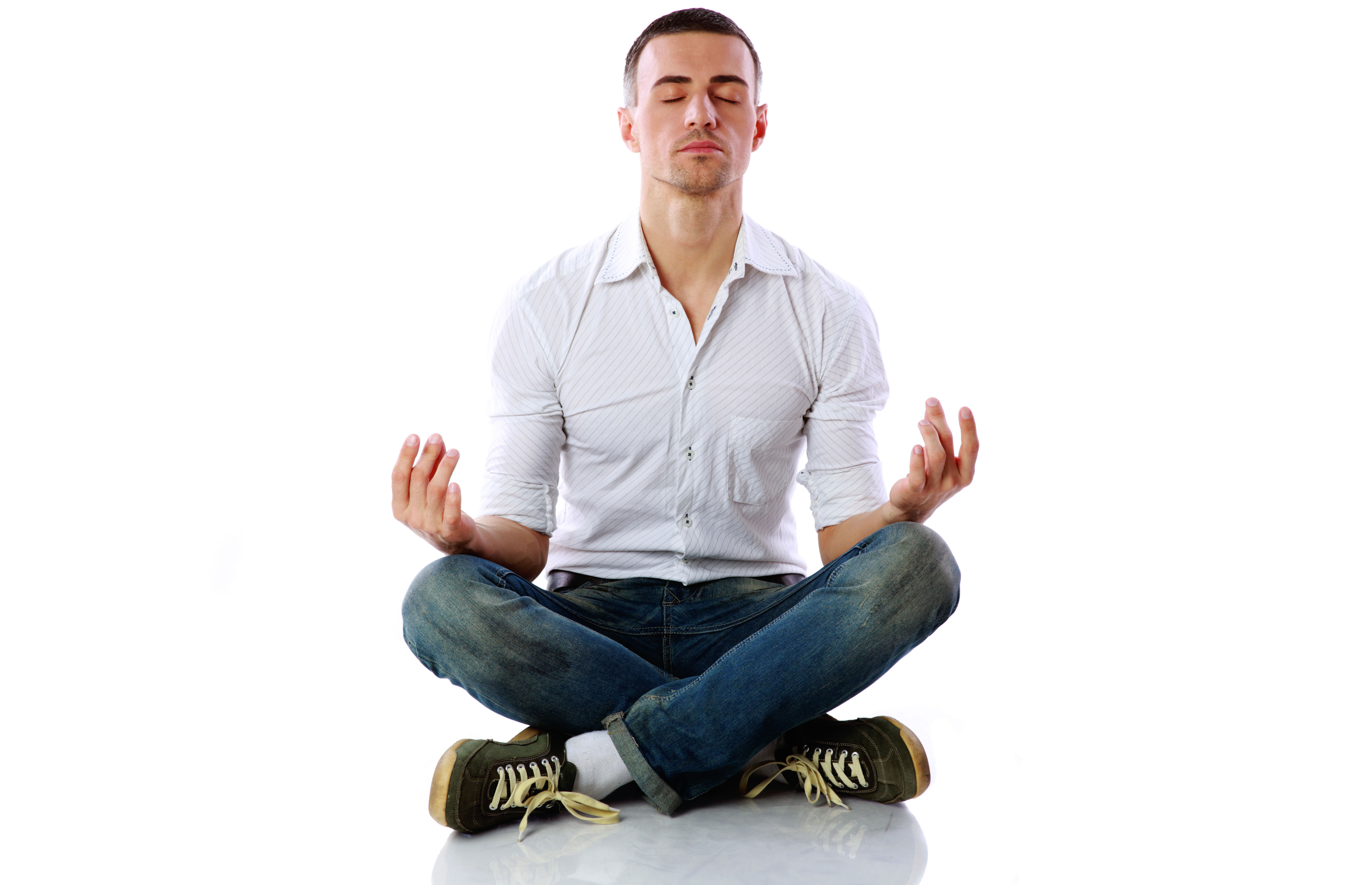 Homem de pernas cruzadas e mãos sobre os joelhos faz meditação com olhos fechados